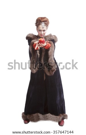 Beautiful portrait of woman witch with red apple  in fashion  fur coat isolated on white background