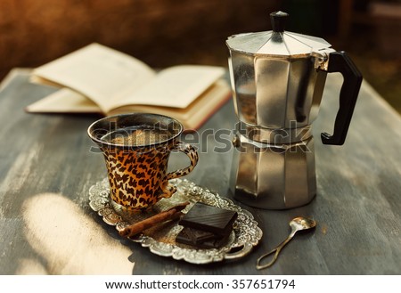 Instagram looking picture of cup of coffee, vintage moka pot, chocolate and cinnamon. Color toned with filters. Selective focus, Shallow Depth of field