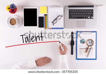 Business Concept: Businessman writing the words TALENT