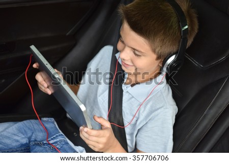 Kid watching moving on tablet inside car