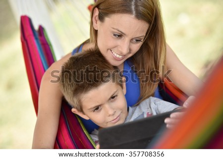 Mother and son in hammock using tablet