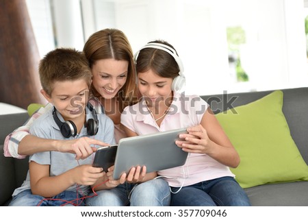 Mother with kids playing with digital tablet