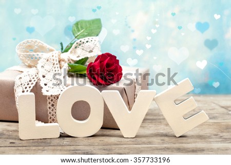 Gift box with red rose and wooden letters LOVE