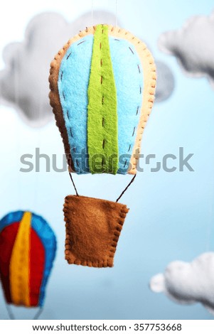 Fleece clouds and balloons on light blue background