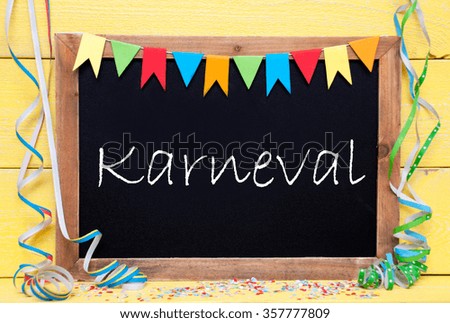 Chalkboard With German Text Karneval Means Carnival. Party Decoration Like Streamer, Confetti And Bunting Flags. Yellow Wooden Background With Vintage, Retro Or Rustic Syle