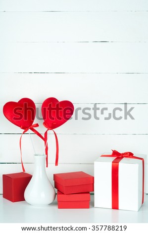Valentines Day. Gift boxes and hearts in a white vase on a wooden background. Valentines background with copyspace