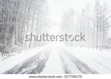 Snowy winter road during blizzard in Latvia. Heavy snow storm. Royalty-Free Stock Photo #357798170