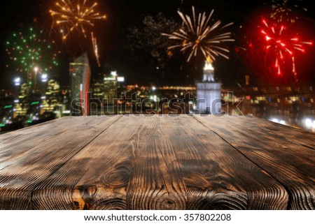 background of city at night and worn old table of wood 