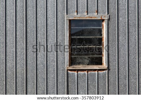 Glass louvered window in rustic galvanized iron clad wall.