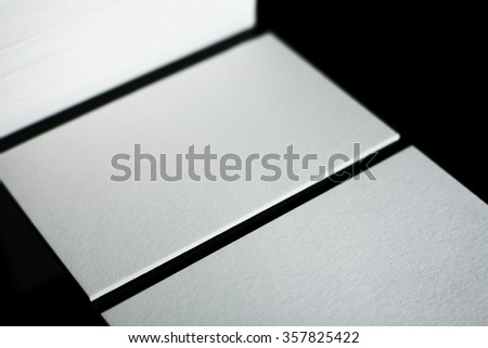 Blank white business cards on black background. Photo mock-up.