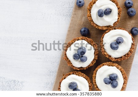 Blueberry tarts on a wooden platter, healthy dessert tart snack Royalty-Free Stock Photo #357835880