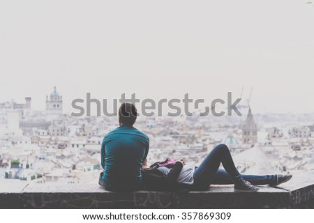 Young couple is relaxing and enjoying the view of the city. Toned picture Royalty-Free Stock Photo #357869309