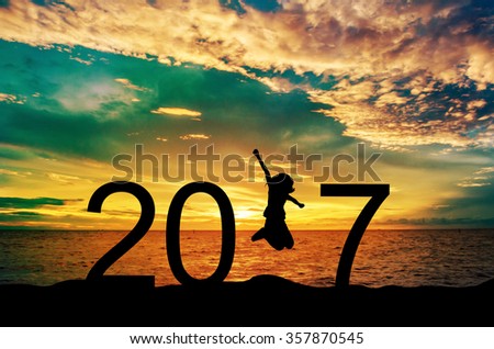 Silhouette young woman jumping on the sea and 2017 years while celebrating new year Royalty-Free Stock Photo #357870545