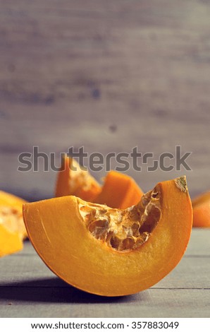 Pumpkin slices with seeds on a wooden background. Selective focus.