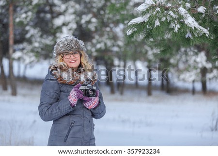 Girl in winter park on a retro camera