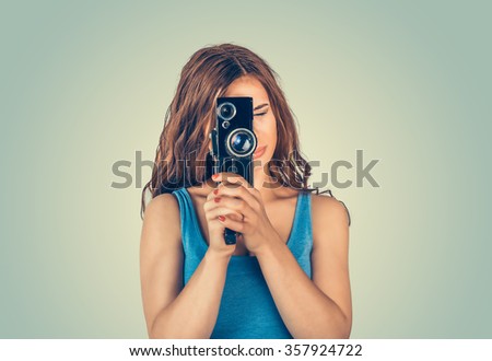 Woman recording. Closeup portrait young person photographer girl shooting images taking pictures with copyspace isolated green wall background. Human facial expression emotions feelings body language 