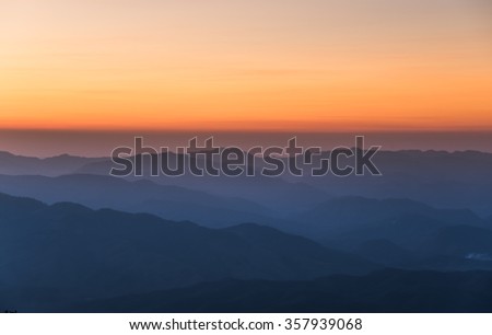 Sunset and foggy mountain valley landscape.