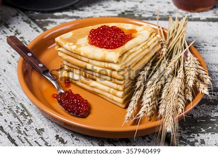 Pancakes with salmon caviar traditional Russian meal on wooden background Royalty-Free Stock Photo #357940499