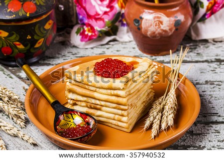Pancakes with salmon caviar traditional Russian meal on wooden background Royalty-Free Stock Photo #357940532