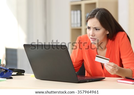 Casual buyer worried with problems buying on line with a credit card and a laptop in a little office or home   Royalty-Free Stock Photo #357964961