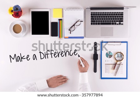Business Concept: Businessman writing the words MAKE A DIFFERENCE