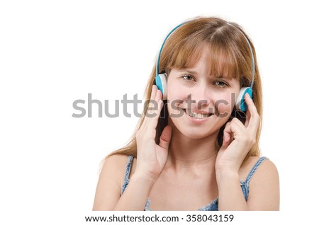 The young and beautiful woman in blue earphones listens to music smiling