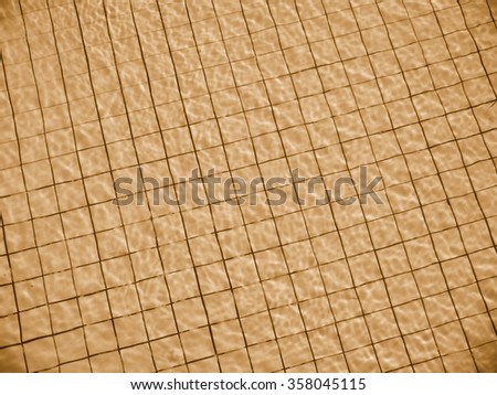 light reflection on water surface of swimming pool with gold color tiles on the bottom    