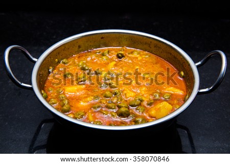 Indian dish green gram with tomato curry and potatoes purely vegetarian, spicy and delicious shot on black granite slab