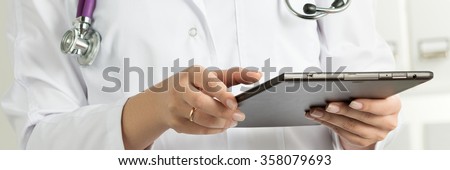 Female Doctor Holding Tablet PC. Doctor's hands close-up. Medical service and health care concept. Letterbox format