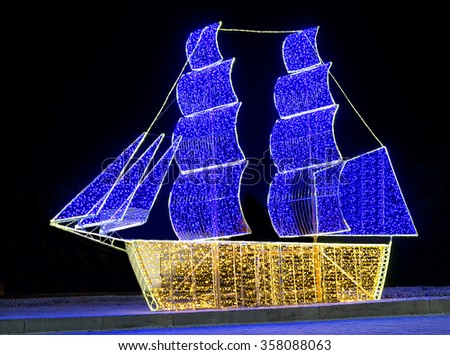 Christmas ship from multicolored lights on black background