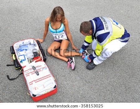 A Paramedic helping a female runner wiht ankle accident