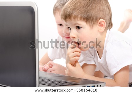 Two boys looking on laptop screen, closeup, on a white background