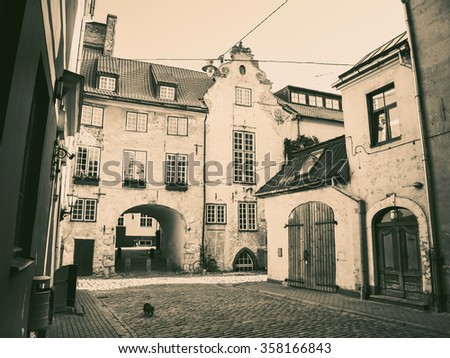 Black and white retro styled photo of morning medieval street in the old city of Riga, Latvia