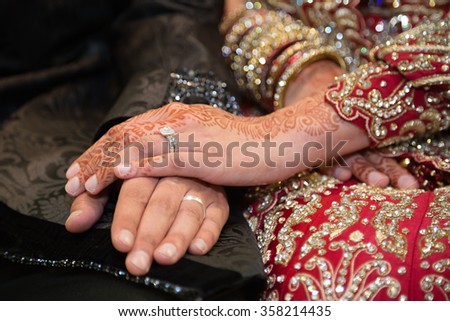 Bride holding grooms hand focus on brides ring