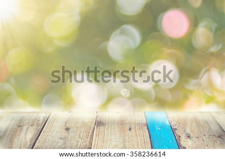 Nature leaf bokeh with sun light on old empty wood table background.Product presentation in nature
