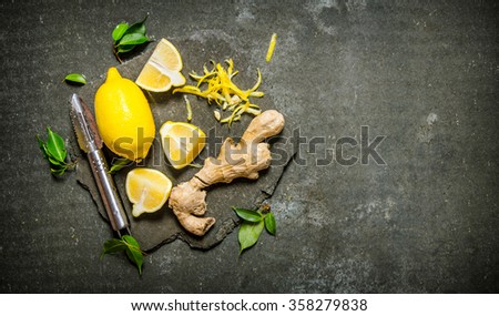 Lemon zest, ginger and leaves on a stone stand. On the stone table. Free space for text . Top view