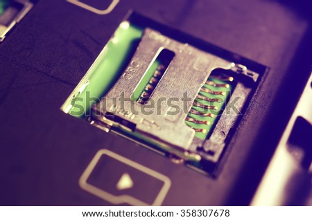 Socket for memory card micro-SD. Metal contacts. Close-up view. Logo memory card. Vintage toning.