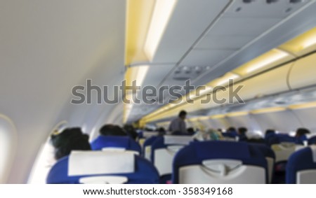 Blurred image of airplane interior / cabin with passengers on-board 