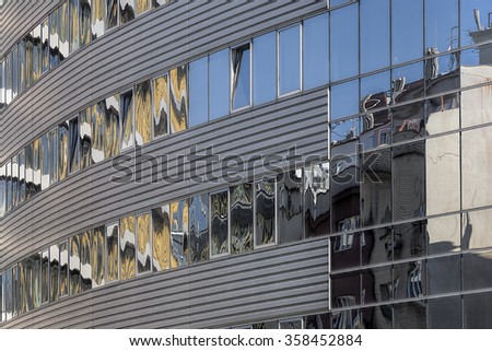 Modern abstract architecture detail with reflection of old houses.