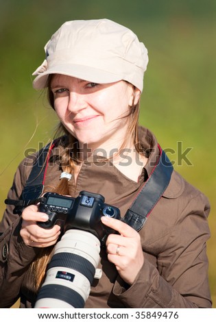 Beautiful young female nature photographer outdoors