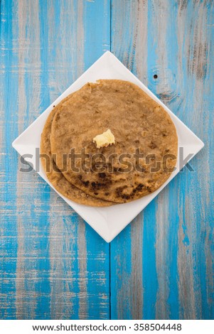 Indian dessert sweet Hot Mawa / Khoya Roti with ghee also known as Khavyachi Poli in Marathi, served in a plate over colourful or wooden background. Selective focus