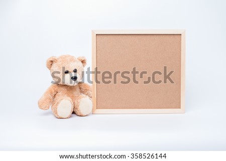 Teddy bear with a wooden frame on a white background.
