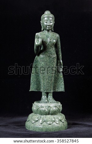 Jade sculpture of buddha isolated on black background.