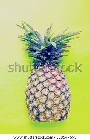 pineapple in a sunglasses on green background.