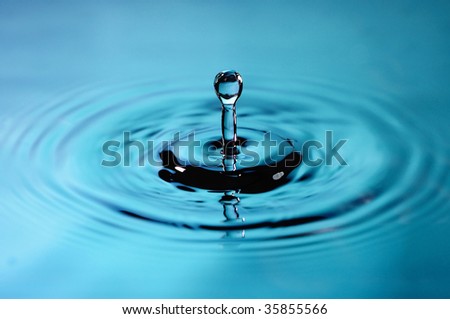 A droplet splashing over calm water macro
