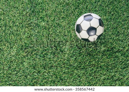 soccer ball on green grass field.vintage filter effect on photo