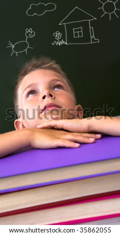 Face of diligent schoolboy looking upwards with his head on stack of books over black background with pictures on it