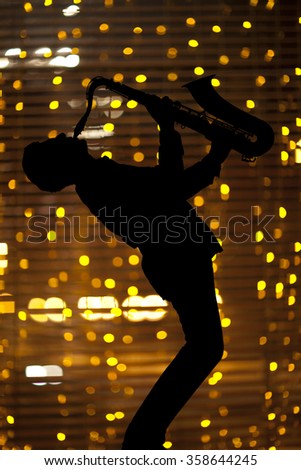 Saxophonist. Man playing on saxophone against the background of beautiful light