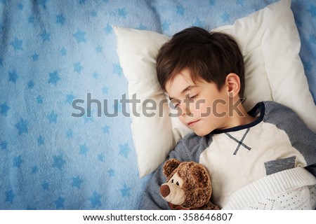 six years old child sleeping in bed with alarm clock Royalty-Free Stock Photo #358646807