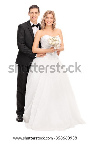 Full length portrait of a young bride and groom posing together isolated on white background